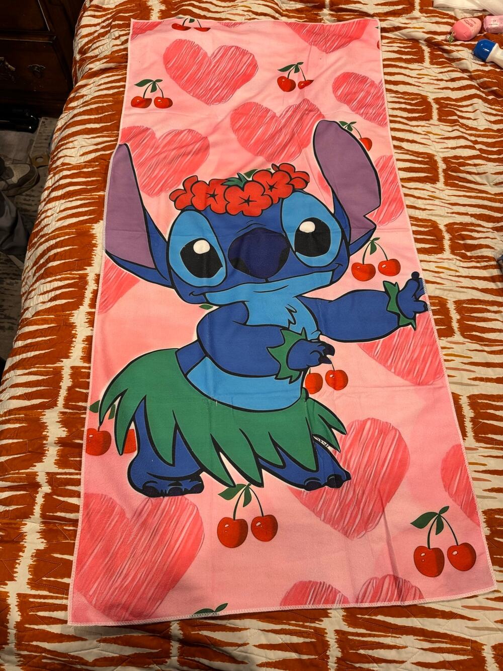 Stitch beach towel hula skirt and flower crown surrounded by hearts and cherries
